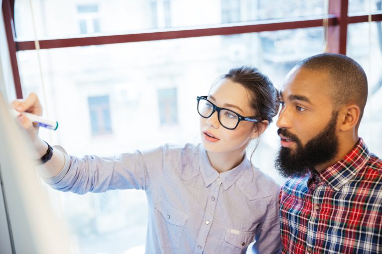Young business people working with whiteboard in office